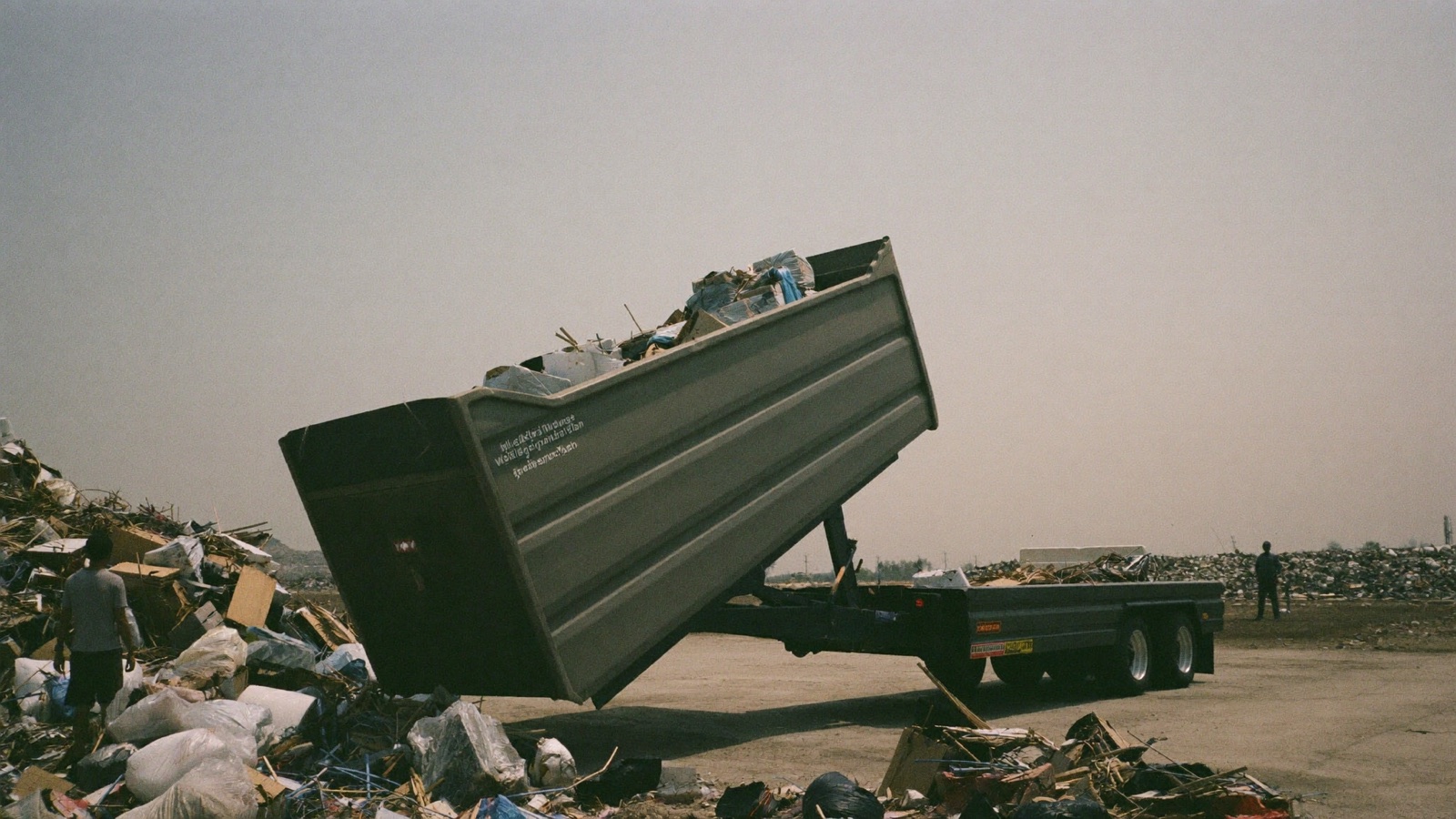 Dump trailer tilted up unloading junk at a landfill
