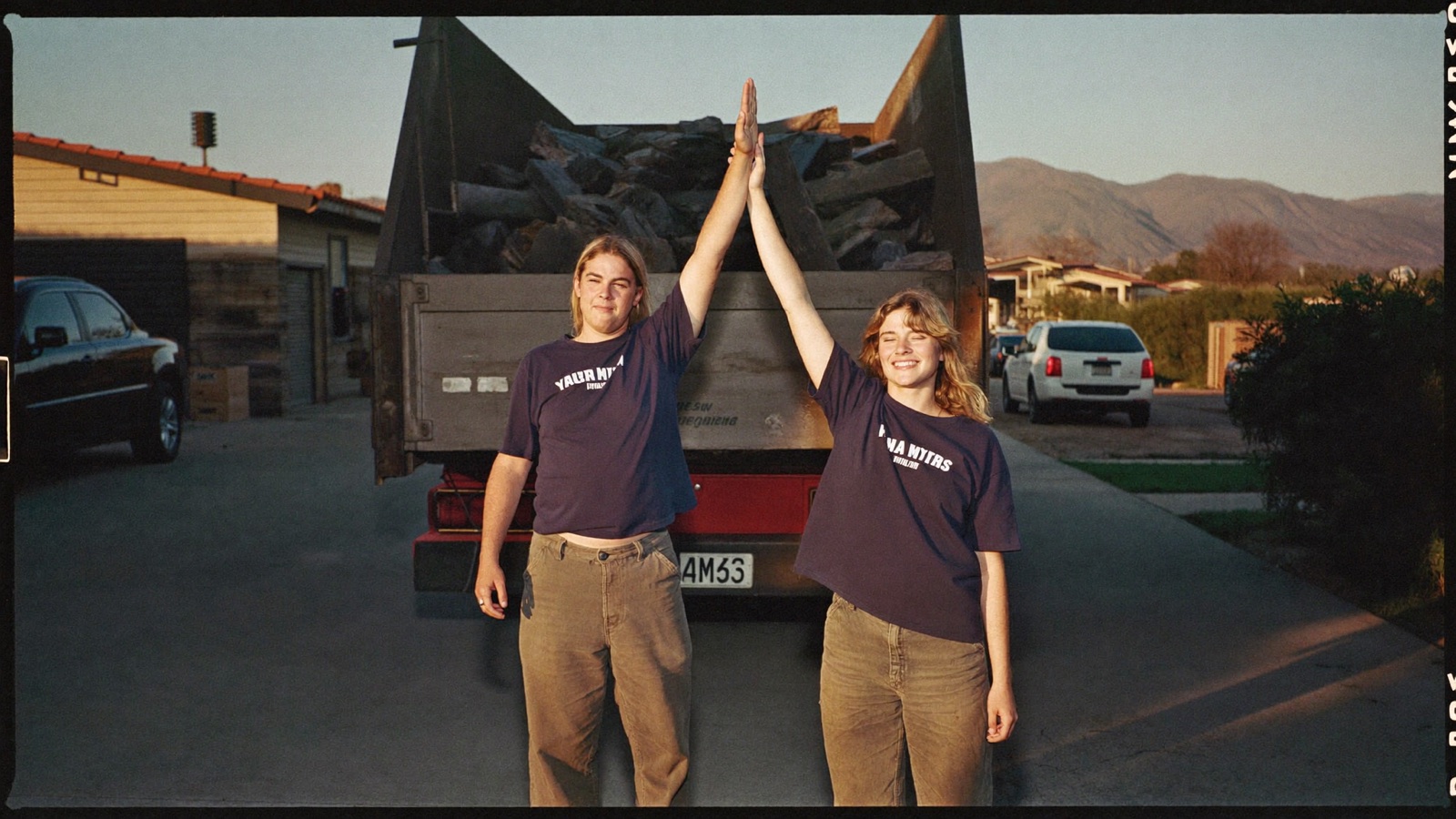 Junk removal owner standing proudly next to his first pickup truck